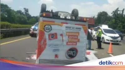 Mobil Boks Pengangkut Air Mineral Terbalik di Tol Jagorawi Akibat Pecah Ban